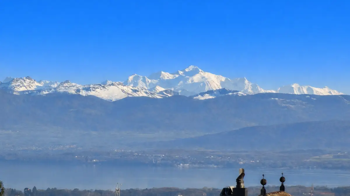 Vue panoramique des montagnes enneigées surplombant le lac.