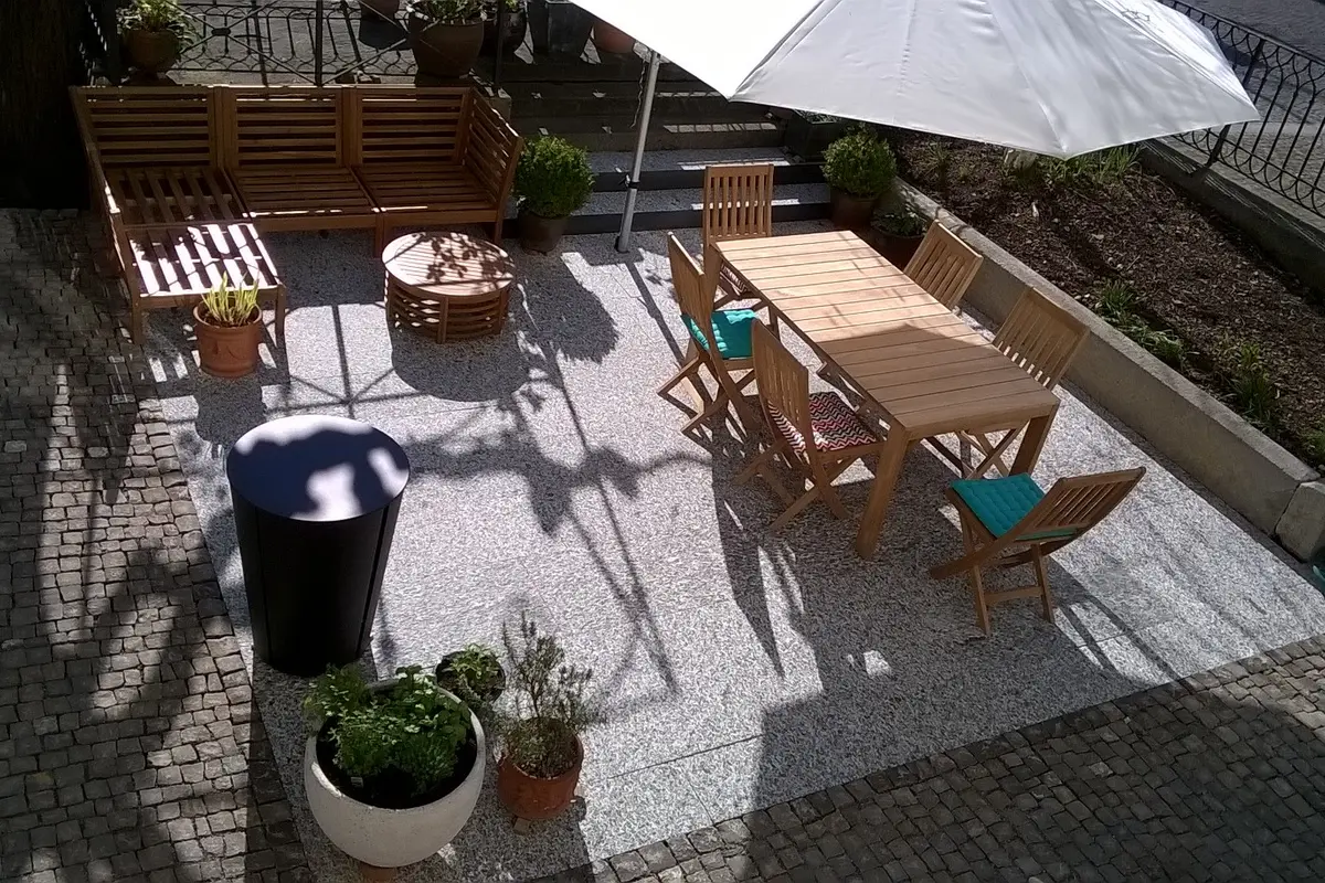 Überdachte Terrasse mit Sitzbereich und Pflanzendekoration.