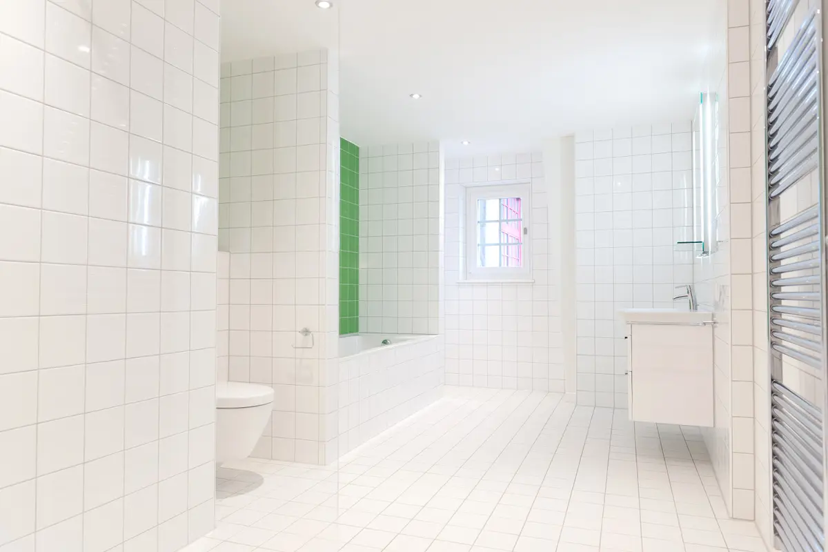 Modernes Bad mit Badewanne und Tageslichtfenster.