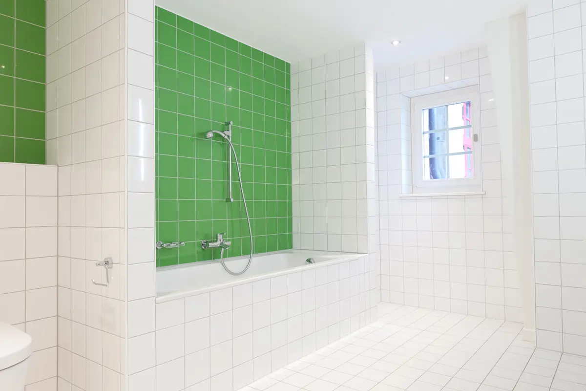 Modernes Badezimmer mit grünen Akzenten und Badewanne.