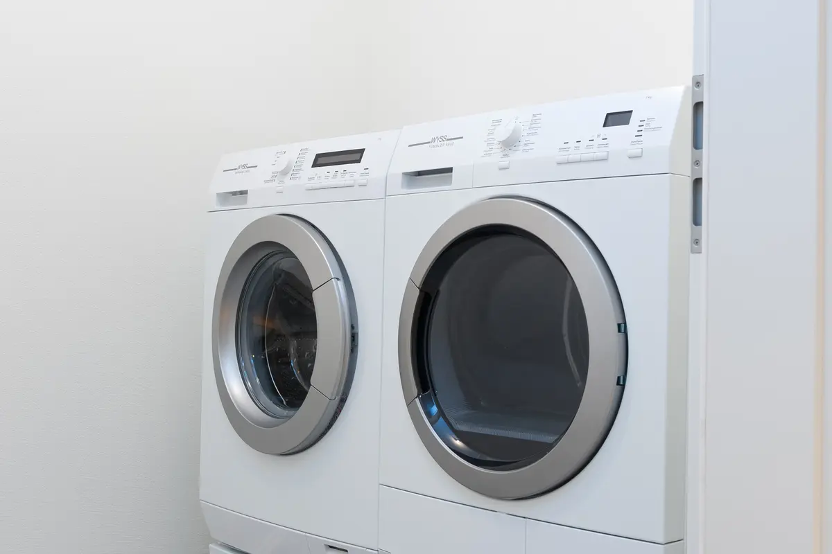 Waschküche mit moderner Waschmaschine und Trockner.