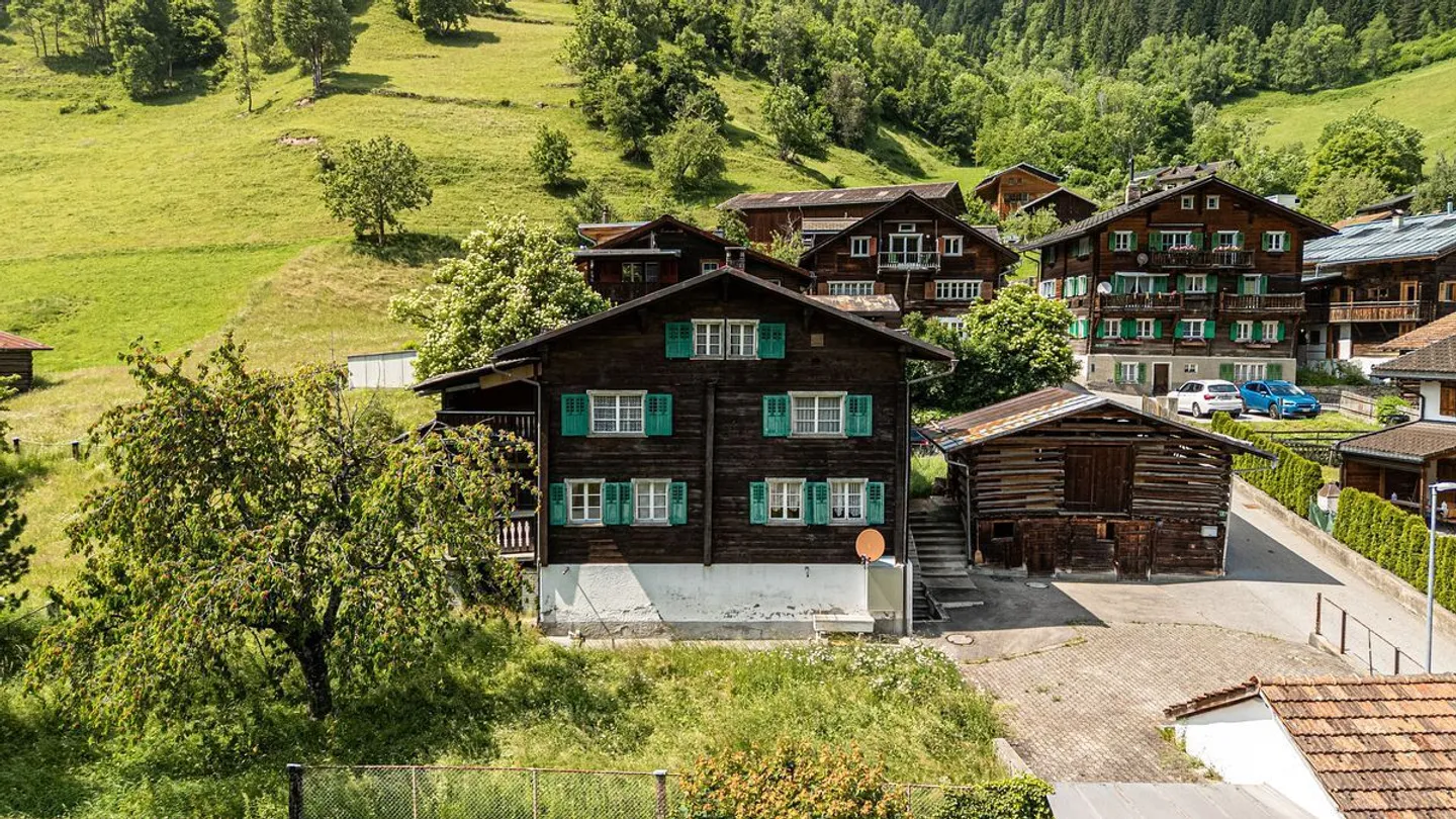 Building land with existing structures and a paradisiacal view of the greenery and the Grisons mountains - Photo 2 of 13