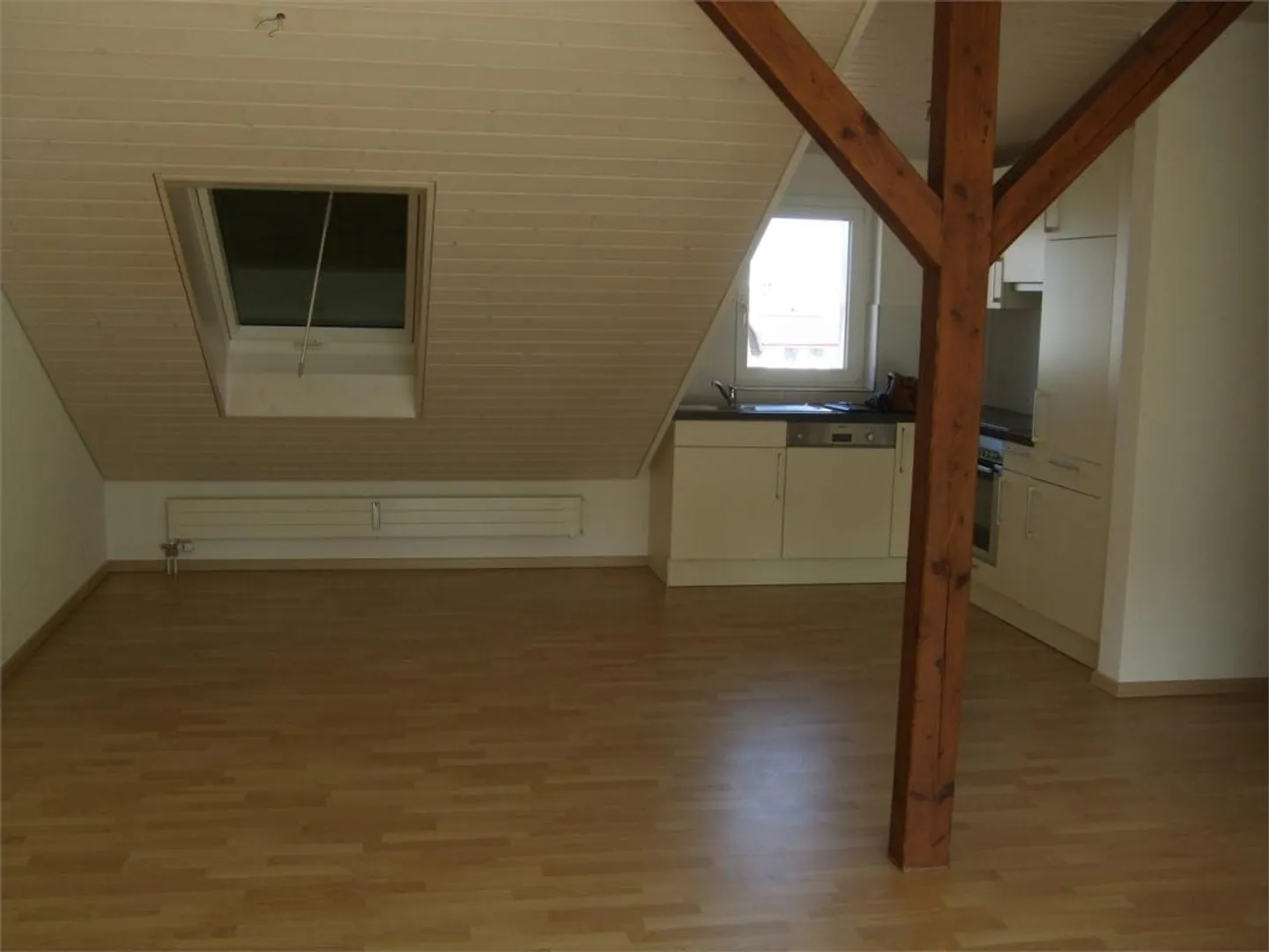 Modern, bright penthouse apartment with south-facing balcony, visible beams, open kitchen - Photo 4 of 7