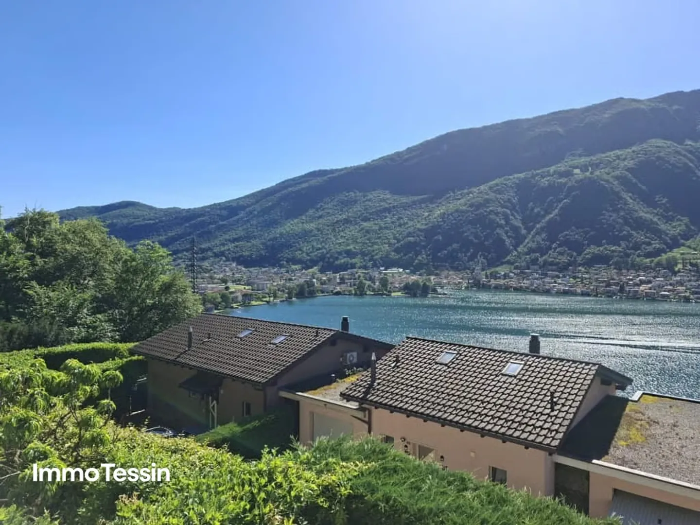 Élégante maison avec une vue fantastique à 180 degrés sur le lac de Lugano dans un bel emplacement avec jardin et plusieurs places de parking - Photo 1 sur 13