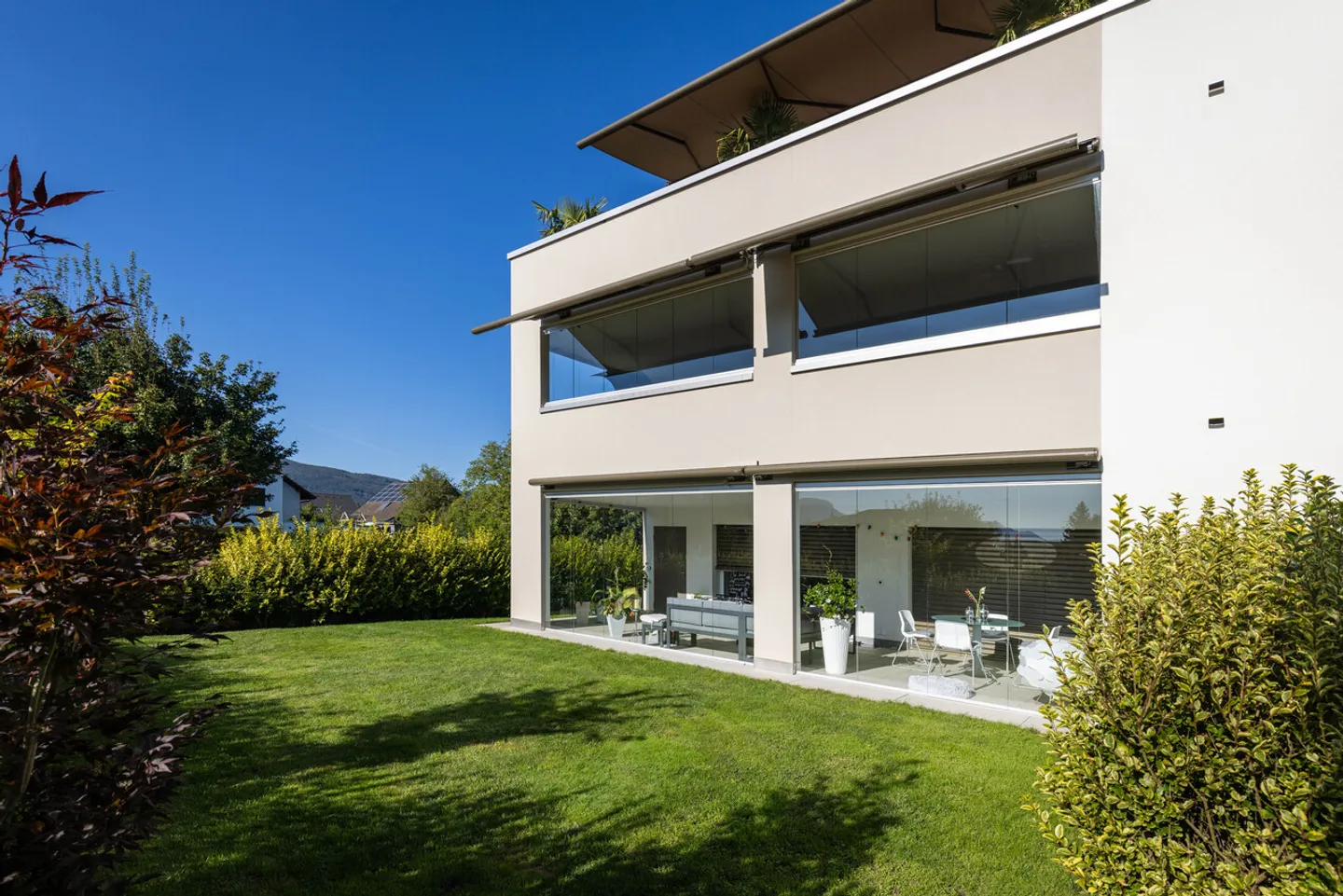 Ruhig gelegene, hochwertige, helle und moderne 4.5 Zimmer Terrassenwohnung im Obergeschoss mit 30 m² Wintergarten mit Weitsicht gegen Westen (Abendsonne), 2 Parkplätze inkl. und Gemeinschaftsgartengarten mit rundum Sichtschutz und Solitärbäumen - Foto 4 von 108