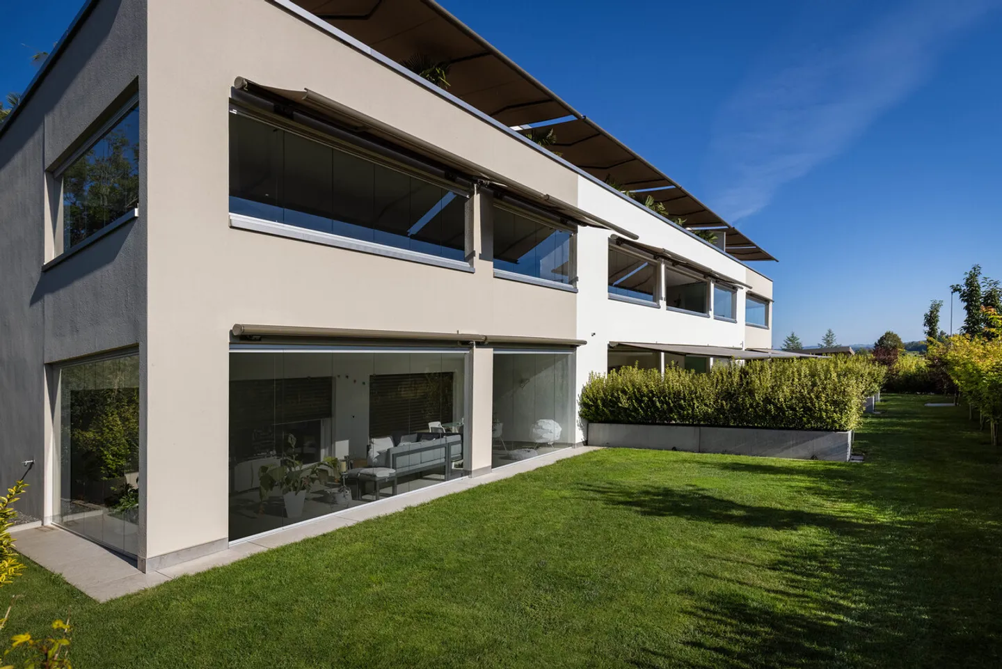 Ruhig gelegene, hochwertige, helle und moderne 4.5 Zimmer Terrassenwohnung im Obergeschoss mit 30 m² Wintergarten mit Weitsicht gegen Westen (Abendsonne), 2 Parkplätze inkl. und Gemeinschaftsgartengarten mit rundum Sichtschutz und Solitärbäumen - Foto 3 von 108