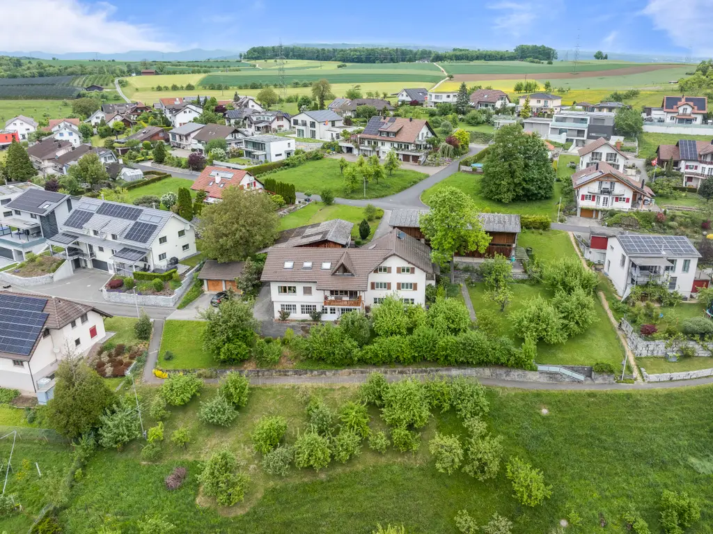 Geräumiges Familienhaus mit zwei zugebauten Wohnungen, diversen Hobby-, Einstell- und Lagermöglichkeiten inkl. Baulandparzelle