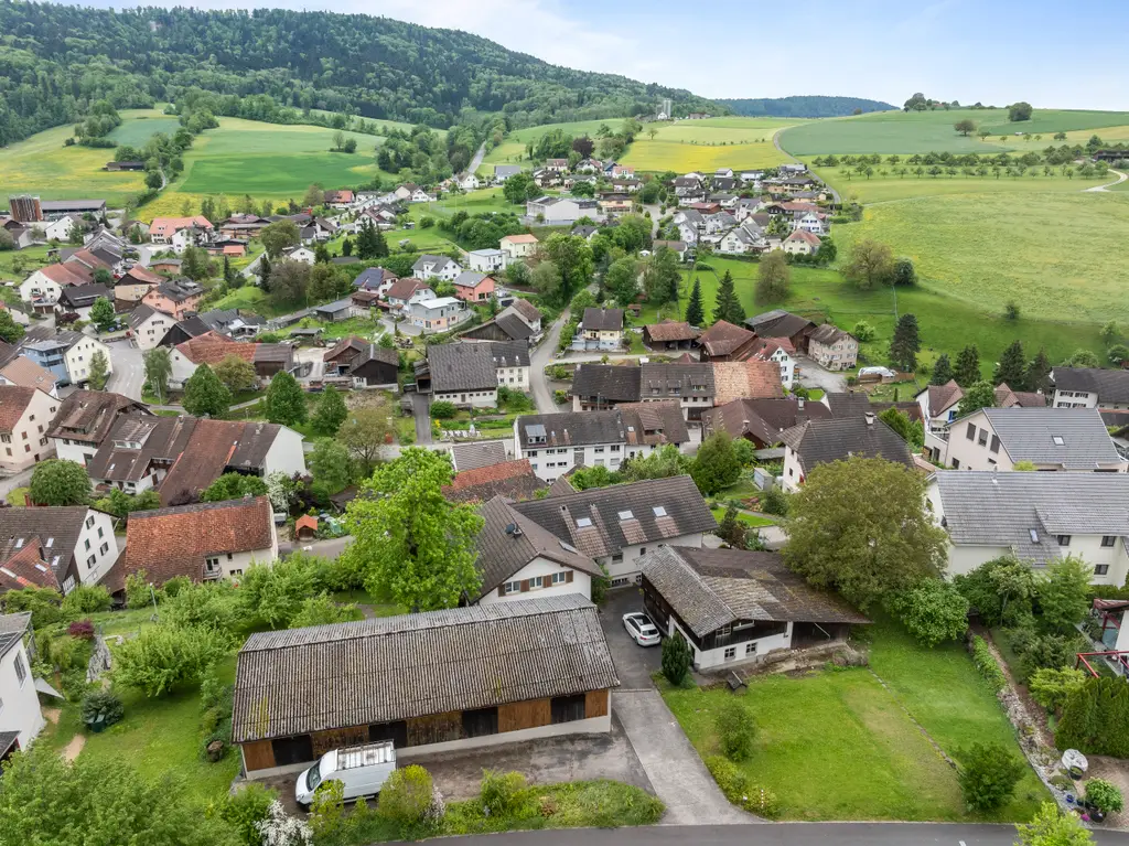 Geräumiges Familienhaus mit zwei zugebauten Wohnungen, diversen Hobby-, Einstell- und Lagermöglichkeiten inkl. Baulandparzelle