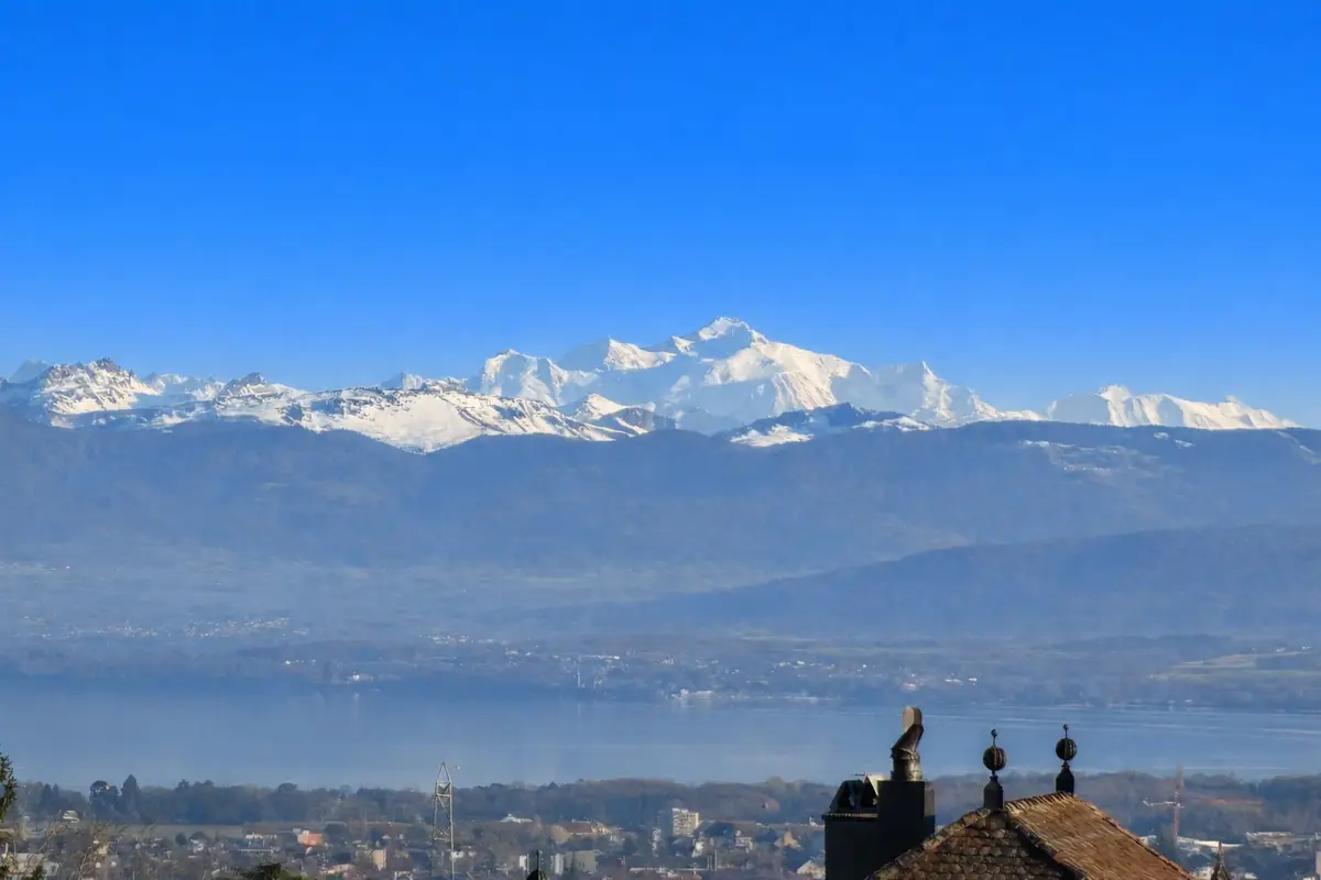 Vue panoramique des montagnes enneigées surplombant le lac.